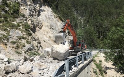 scavatore meccanico in azione per rimozione della frana sulla strada