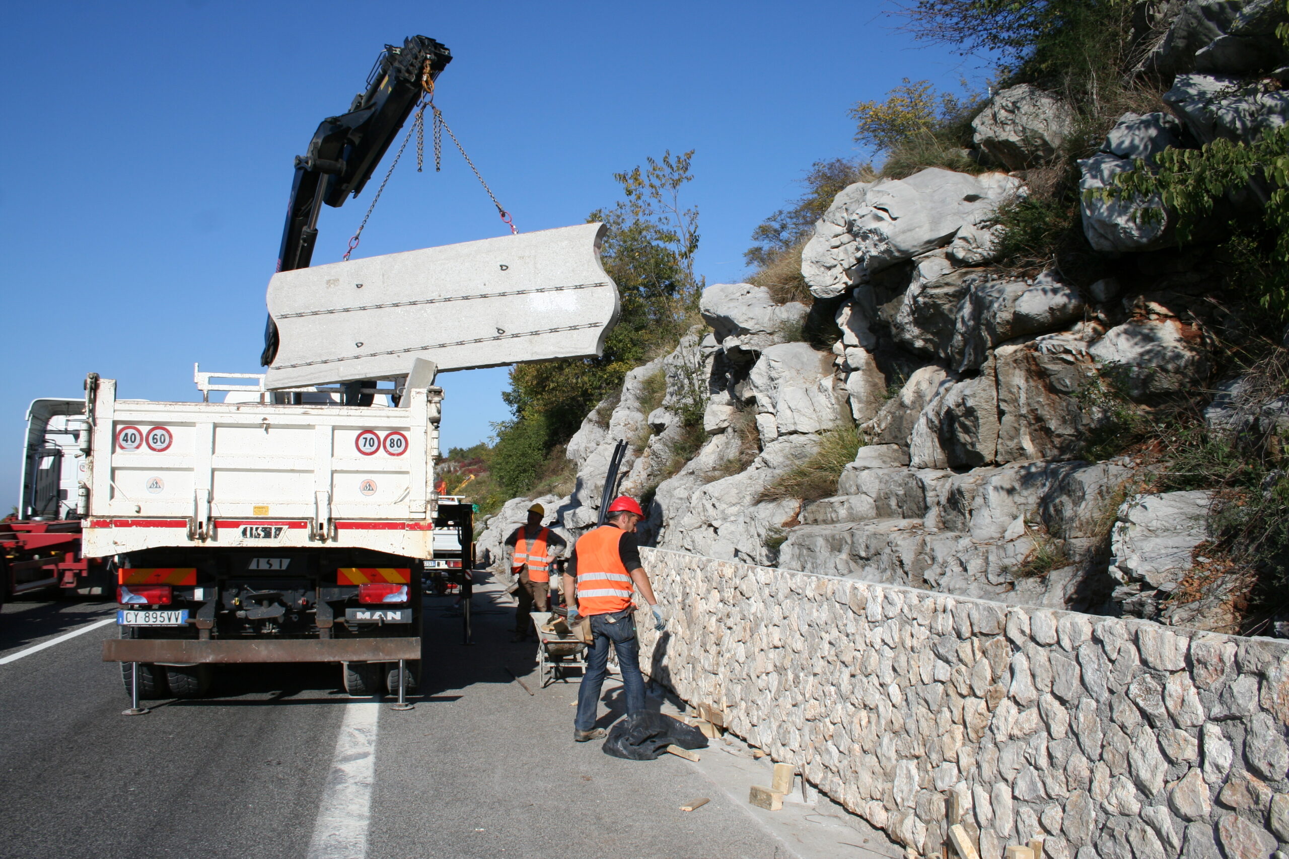 Posizionamento mediante gru di barriera paramassi a bordo autostrada